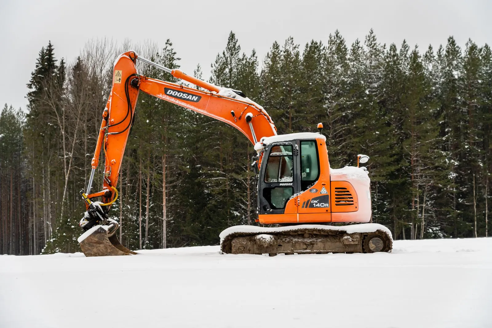 Grävmaskin i snötäckt skog